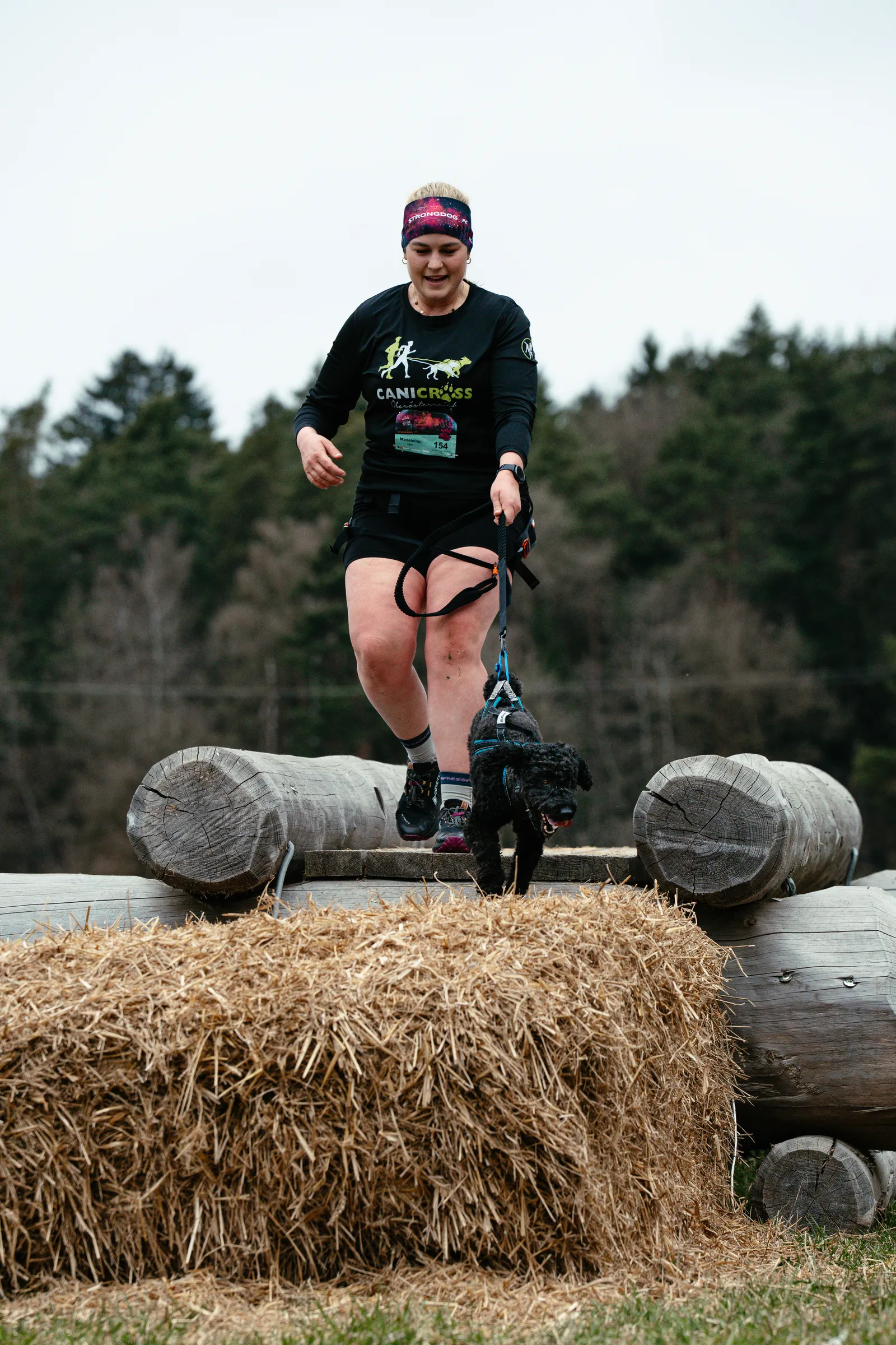 Canicross Sprung von Strohballen mit Hund – Hindernislauf