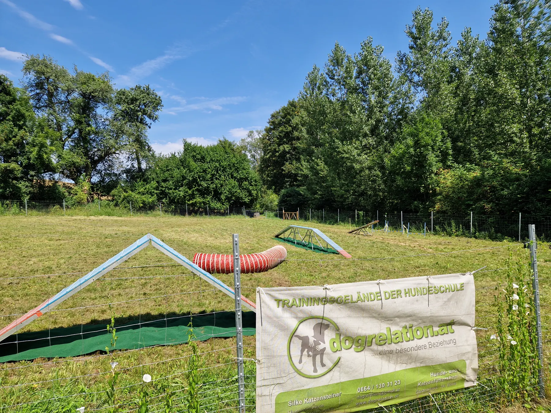 Trainingsgelände der Hundeschule Dogrelation mit Banner und Agility-Tunnel – Hundeplatz Wolfern